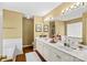 Bright bathroom featuring a double vanity with white cabinets, mirrors, and hardwood flooring at 105 Whimbrel Ln, Mooresville, NC 28117