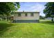 A view of the rear side of the home, displaying three windows and a painted green concrete foundation at 2321 Cline St, Statesville, NC 28677