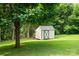 An outdoor storage shed with light-colored siding and green trim is nestled in a green yard at 2321 Cline St, Statesville, NC 28677