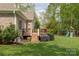 Relaxing backyard with a wooden deck, grill, playset, and manicured lawn for entertaining or play at 233 Highland Forest Dr, Clover, SC 29710