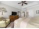 Bright bedroom featuring a ceiling fan, a light green chair, and a wooden dresser with a television at 233 Highland Forest Dr, Clover, SC 29710