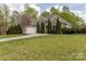 Brick home featuring attached two-car garage, driveway and manicured lawn at 233 Highland Forest Dr, Clover, SC 29710