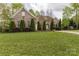 Well-maintained brick home featuring mature landscaping and lush green lawn at 233 Highland Forest Dr, Clover, SC 29710