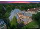 A high angle view of a brick house with a backyard stone patio with a covered kitchen, at dusk at 300 Eagle Bend Dr, Waxhaw, NC 28173