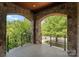 Exterior stone balcony with wrought-iron railing overlooking a treed landscape at 300 Eagle Bend Dr, Waxhaw, NC 28173