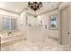 Luxurious bathroom with a soaking tub, walk-in shower, marble flooring, and stylish fixtures at 300 Eagle Bend Dr, Waxhaw, NC 28173