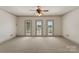Large bedroom with ceiling fan, neutral carpet, and bright french doors leading to the exterior at 300 Eagle Bend Dr, Waxhaw, NC 28173