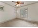 Bright, carpeted bedroom with neutral decor, ceiling fan, and large window with stylish shutters at 300 Eagle Bend Dr, Waxhaw, NC 28173