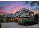 A stunning home with stone and brick accents, complemented by a paved driveway and lush landscaping at twilight at 300 Eagle Bend Dr, Waxhaw, NC 28173