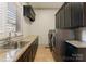 Convenient laundry room featuring granite countertops, tile floors, black cabinets, and stainless steel washer and dryer at 300 Eagle Bend Dr, Waxhaw, NC 28173