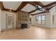 Cozy living room with a stone fireplace, beamed ceiling, and natural light from large windows at 300 Eagle Bend Dr, Waxhaw, NC 28173