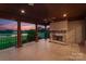 Covered porch with stone fireplace, tile flooring, and a picturesque view of the lawn at 300 Eagle Bend Dr, Waxhaw, NC 28173