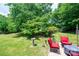 Spacious backyard featuring a patio set, lush lawn, mature trees, and privacy at 1008 2Nd Se St, Conover, NC 28613