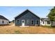 A blue home's back exterior with a white door and trim with a hay covered lawn at 1017 S Main St, Granite Quarry, NC 28146