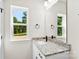 Bright bathroom with a granite countertop vanity, matte black faucet, and a window view at 1017 S Main St, Granite Quarry, NC 28146