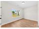 Bright, empty bedroom features wood floors, a window, and white walls at 1017 S Main St, Granite Quarry, NC 28146