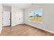 A bedroom features light wood floors, a double door closet, and a bright window at 1017 S Main St, Granite Quarry, NC 28146