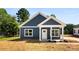 A charming blue home's exterior with a white door and trim and a hay covered lawn at 1017 S Main St, Granite Quarry, NC 28146