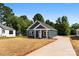 A charming blue home's exterior with a white door and trim and a hay covered lawn at 1017 S Main St, Granite Quarry, NC 28146