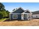 A charming blue home's exterior with a white door and trim and a hay covered lawn at 1017 S Main St, Granite Quarry, NC 28146