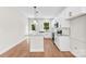 Bright kitchen with white cabinets, granite counters, stainless appliances, island, and wood-look floors at 1017 S Main St, Granite Quarry, NC 28146