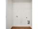 Bright laundry room with wooden floors, ready for appliances, and featuring wire shelving at 1017 S Main St, Granite Quarry, NC 28146