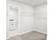Walk-in closet with wire shelving and an adjacent laundry room featuring a washing machine at 144 Satchel Ct, Mooresville, NC 28115