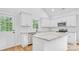 Well-lit kitchen featuring white cabinets, stainless steel appliances, granite counters, and wood floors at 7 S Coulter Ave, Newton, NC 28658