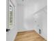 Well-lit laundry room with hardwood floors, storage shelf, and a window view at 7 S Coulter Ave, Newton, NC 28658