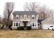 Traditional two-story home features tan siding, neutral shutters, and a welcoming front porch at 9232 Chislehurst Rd, Mint Hill, NC 28227