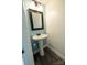 Quaint powder room with pedestal sink, framed mirror, and sleek flooring at 9232 Chislehurst Rd, Mint Hill, NC 28227