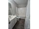 Standard bathroom featuring a tub-shower combo, sink and dark plank floors at 3320 Hunting Wood Ct, Gastonia, NC 28052