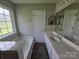 Bright bathroom featuring a tub, vanity, and a large mirror at 3320 Hunting Wood Ct, Gastonia, NC 28052