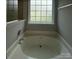 Close-up of a bathtub with a tiled window and chrome fixtures at 3320 Hunting Wood Ct, Gastonia, NC 28052