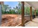 View of a spacious backyard surrounded by a lush forest, seen from a covered porch with dark railings at 4615 Yellow Poplar Ln, Concord, NC 28025