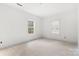 Bright bedroom featuring two windows, white walls, and unfinished floors, offering a clean, modern aesthetic at 4615 Yellow Poplar Ln, Concord, NC 28025