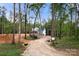 Charming two-story home with modern design set amidst lush trees and gravel driveway, combining nature and style at 4615 Yellow Poplar Ln, Concord, NC 28025
