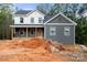 Two-story home featuring a welcoming front porch and gray and white siding in a wooded neighborhood at 4615 Yellow Poplar Ln, Concord, NC 28025
