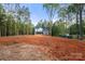 Two-story home with dark roof and white siding stands on bare land surrounded by green trees, ready for landscaping at 4615 Yellow Poplar Ln, Concord, NC 28025