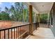 Covered porch with black railing overlooking a wooded backyard at 4615 Yellow Poplar Ln, Concord, NC 28025