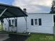 A partially obscured view of a home featuring light siding with an adjacent carport structure at 104 Franklin St, Clover, SC 29710