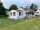 A cozy single-Gathering home surrounded by a lush lawn, with a chain-link fence for added security at 104 Franklin St, Clover, SC 29710