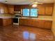 Classic kitchen features wood cabinets, laminate flooring, and modern appliances for comfortable cooking at 104 Franklin St, Clover, SC 29710