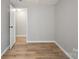 Bedroom with light gray walls and wood-look floors, with an open doorway to another room at 1354 Springwood Ln, Rock Hill, SC 29730