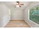 Bedroom with light gray walls, wood-look floors, ceiling fan and a window with wooded outdoor views at 1354 Springwood Ln, Rock Hill, SC 29730