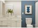 Well-lit bathroom with a double sink vanity, white cabinets, and a modern framed artwork at 1616 Swallow Tail Dr, Cramerton, NC 28012