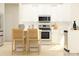 Bright kitchen with white cabinets, stainless steel appliances, and modern bar stool seating at 1616 Swallow Tail Dr, Cramerton, NC 28012