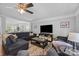 Inviting living room featuring a ceiling fan, large TV, and plush seating area at 10418 Cullen Ct, Charlotte, NC 28278