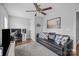 Cozy living room featuring a ceiling fan, plush rug, and comfortable couch at 10418 Cullen Ct, Charlotte, NC 28278