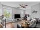 Bright living room features wood floor, natural light, ceiling fan, and TV at 10418 Cullen Ct, Charlotte, NC 28278